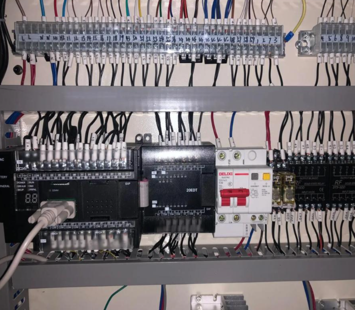 环保工程师正在调试垃圾渗滤液处理设备的PLC控制柜,现场环境整洁专业